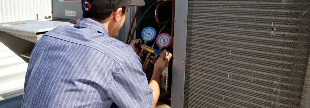 HVAC technician servicing a condenser unit in Hilton Head Island